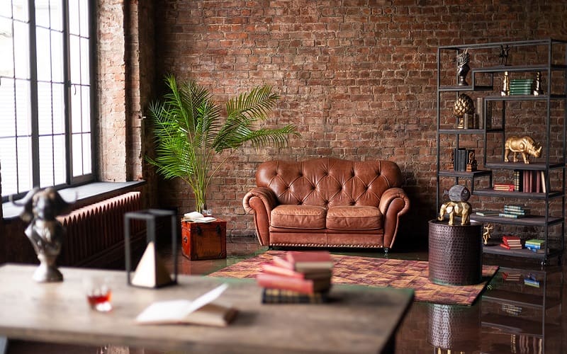 Living room decor with light brown couch and brown brick behind