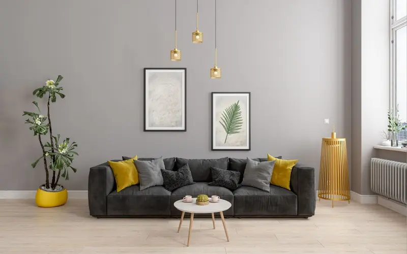 Dark grey sofa with light grey walls and mustard yellow decorations