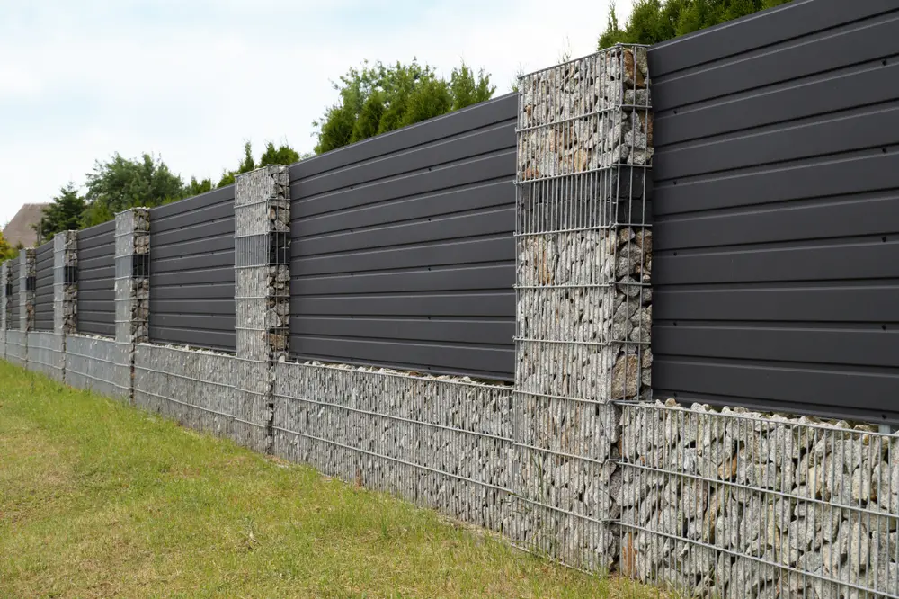 Unique steel on stone, a unique type of fence for a yard, as seen from a walker's position