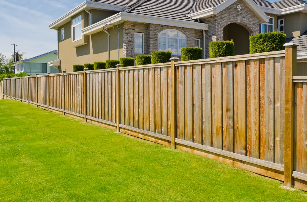 Wooden privacy fence, one of the best types of fences for a yard, as seen running along a suburban backyard