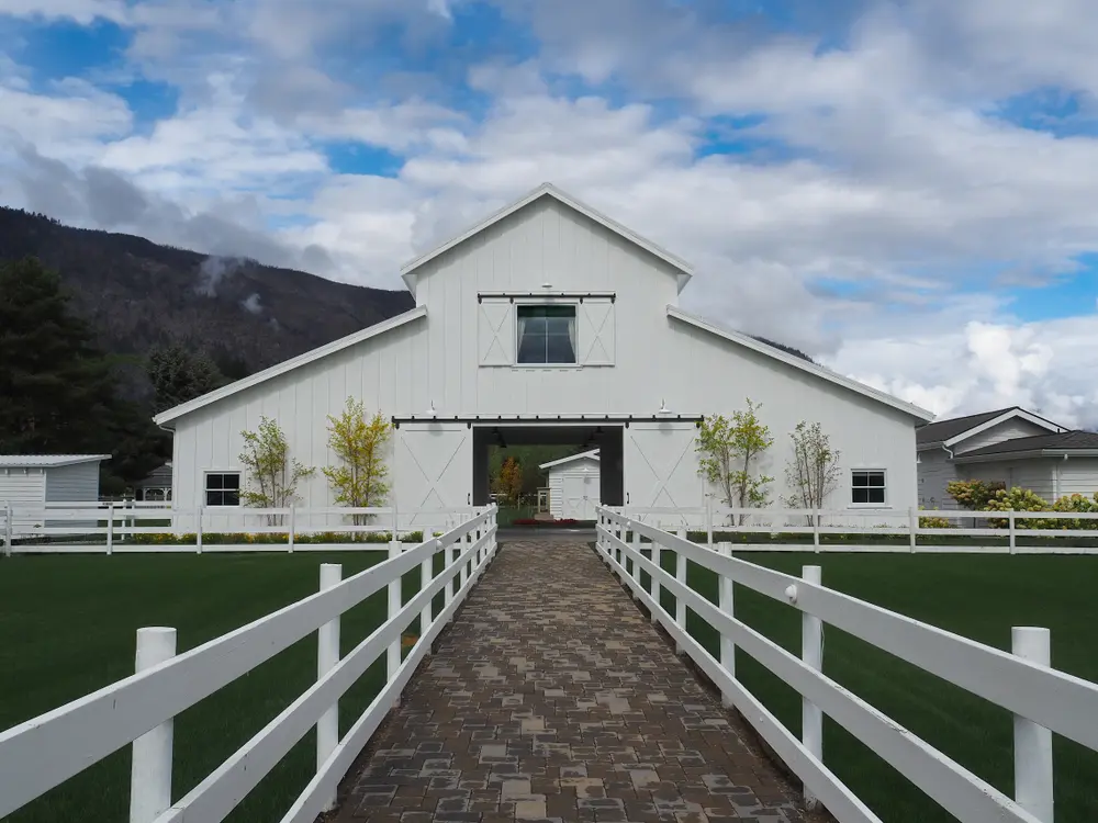 Gorgeous barndominium home pictured from a pathway leading to the home