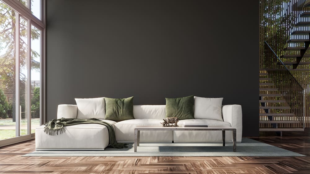 Image of several colors that go with black in a living room with a tan couch and a natural brown wood floor