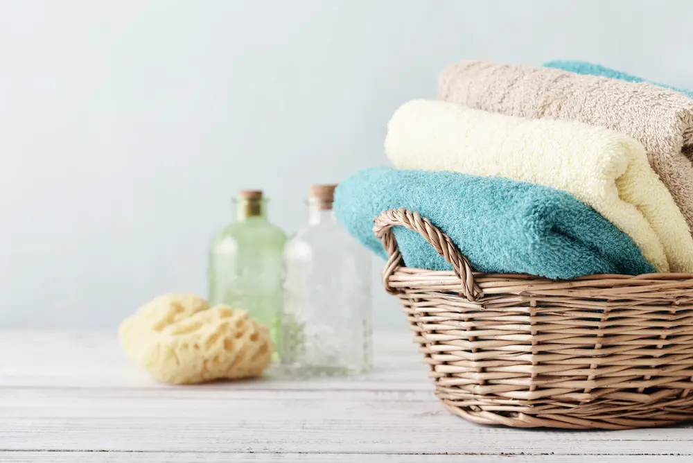 Basket of bath towels in various colors for a guide to the different bath towel dimensions