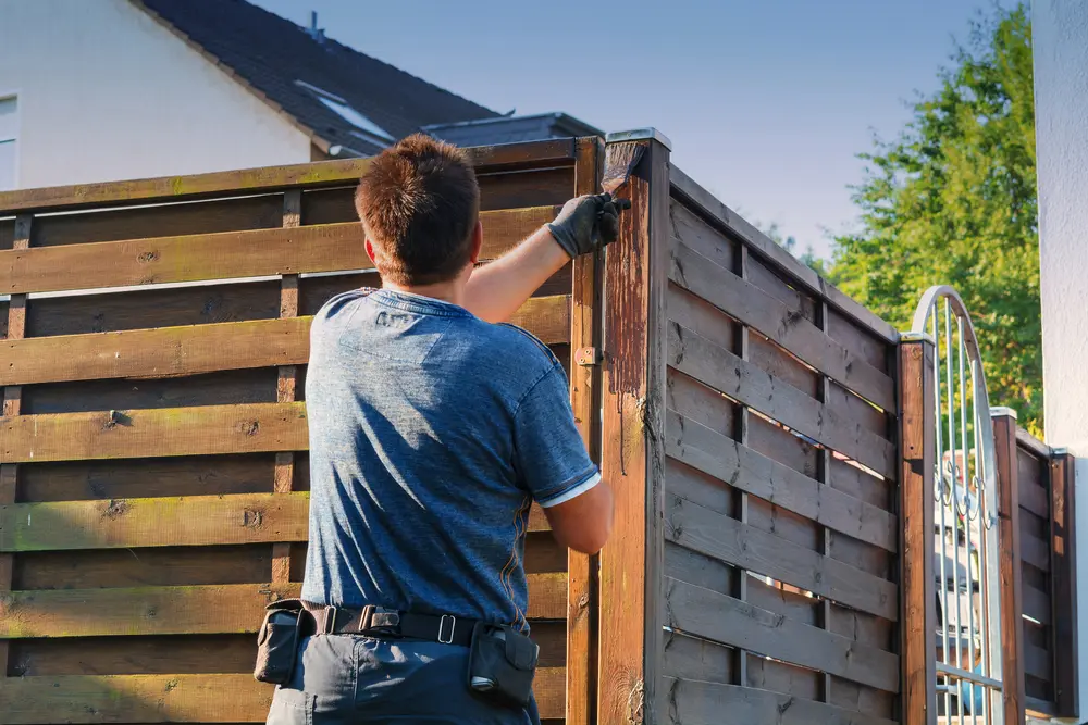 Guy building a privacy fence made of wood