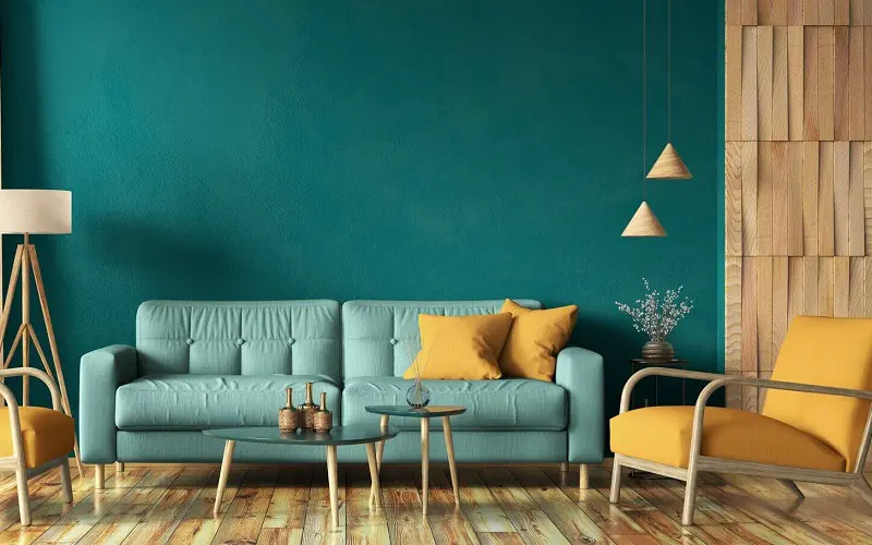 Turquoise sofa with mustard yellow pillows and mustard yellow chairs