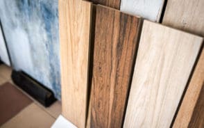 Featured image for a piece on the types of wood grain patterns on several pieces of hardwood flooring stacked vertically