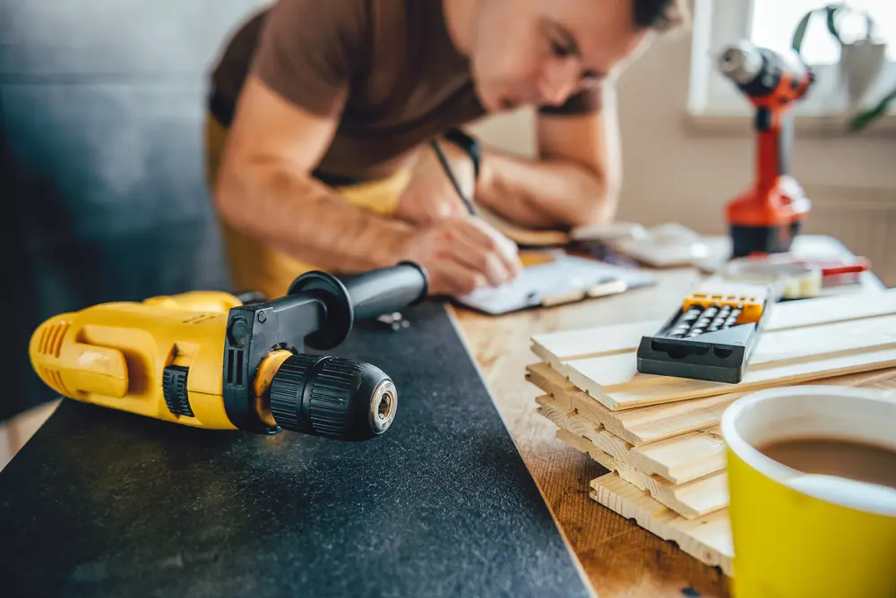 Guy using some of the most common types of power tools in a workshop at home