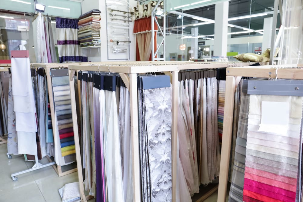 Various types of curtains in mostly neutral and simple patterns in a store